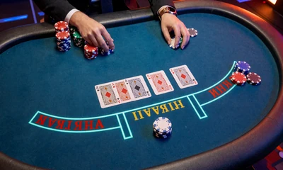 Casino-Hold-em-Tisch mit Gemeinschaftskarten und Chips auf blauem Neonfilz im Betsson Casino